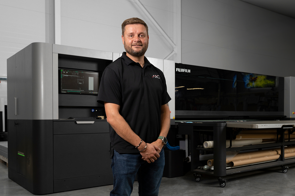ARC UK team member standing beside an industrial large format printer